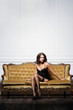 © Acronym - Sexy and beautiful woman in erotic lingerie and stockings posing on a sofa in vintage interior.