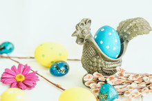 Easter Egg In A Saucer Metal Rooster On White Background