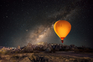 hot air balloon flying over spectacular cappadocia under the sky with milky way and shininng star at