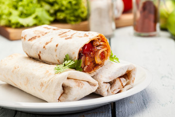 Mexican burritos wraps with mincemeat, beans and vegetables