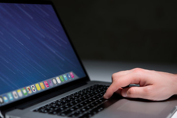 Hand typing on a keyboard of laptop with operating system screen on background