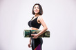 © dianagrytsku - Attractive beautiful young sportswoman holding yoga mat
