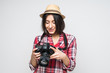 © dianagrytsku - Woman traveler look at taked picture with camera on grey background