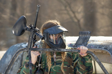 Wall Mural - girl playing paintball in overalls with a gun.