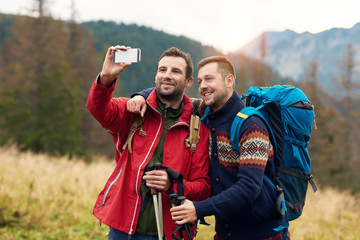 Wall Mural - Hikers taking a selfie while trekking in the wilderness