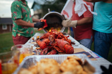 People Preparing A Large Lobster Boil Outdoors