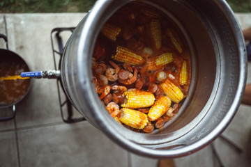 Draining water from a lobster boil in a Keg