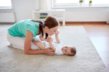 Wall Mural - happy mother playing with baby at home