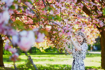 Beautiful young woman in blooming spring park