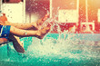 © sakkmesterke - Boys legs splashing water in pool vintage