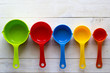 © pospelowa - Colorful measuring spoons for kitchen on a white wooden background