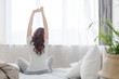 © demphoto - Female stretching sitting on bed in morning