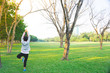 © Nattanee - Woman doing yoga pose on the grass field in city park on sunny day