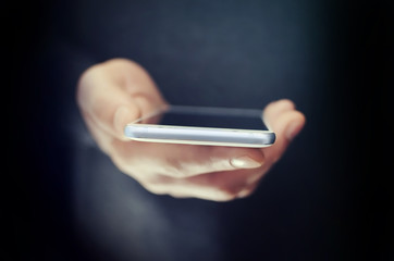 Wall Mural - Angled view of modern phone in man hand 