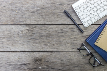 glasses and book on wooden table with soft-focus in the background. over light