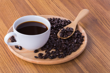 Canvas Print - Coffee cup and beans on wooden background