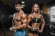 © nikolas_jkd - Sporty sexy couple showing muscle and workout in gym. Muscular man and woman