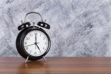 5 o'clock vintage clock on wood table and wall background