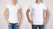 Shirt design and people concept - close up of young man and woman in blank white t-shirt isolated.