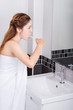 © geargodz - woman in bath towel brushing teeth with mirror in bathroom