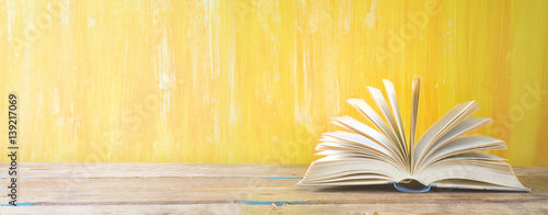 opened book on orange grungy background, panoramic, good copy space Poster Mural XXL