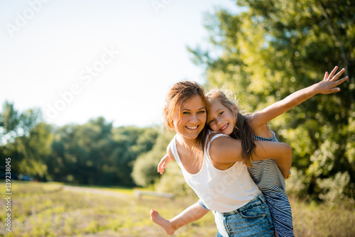 Zdjęcie XXL Szczęśliwi rodzeństwa outdoors na letnim dniu. Zabawa w piggyback.