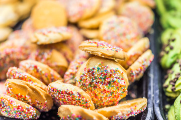 Macro closeup of golden cookies with tiny rainbow sprinkles