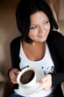 © Raisa Kanareva - young woman sitting in a cafe drinking coffee