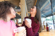 © Davide Angelini - Two young women having fun drinking coffee at the bar