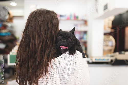 Young Woman Holding Her Adorable Black French Bulldog Puppy In Pet