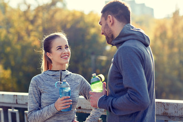 Sticker - smiling couple with bottles of water outdoors