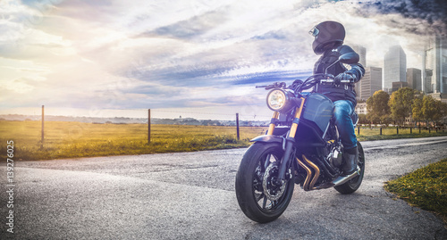 motocyklista-stojacy-na-skrzyzowaniu-patrzacy-na-miasto
