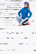 Woman wearing sportswear exercising outside during winter