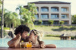 © PhotoAlto - Couple relaxing together in resort pool