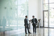 © PhotoAlto - Business associates talking in office lobby