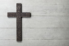 Dark Wooden Cross With Carved The Lord's Prayer On Worn White Wooden Background