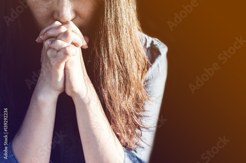 Fotomural Woman praying in meadow at sunset