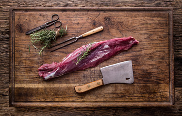 Raw beef meat. Raw beef tenderloin steak on a cutting board with rosemary pepper salt in other positions.