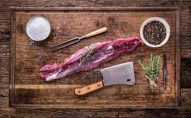 Raw beef meat. Raw beef tenderloin steak on a cutting board with rosemary pepper salt in other positions.