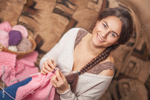 Fotografia, Obraz The woman knits woolen clothes. Knitting needles. natural wool