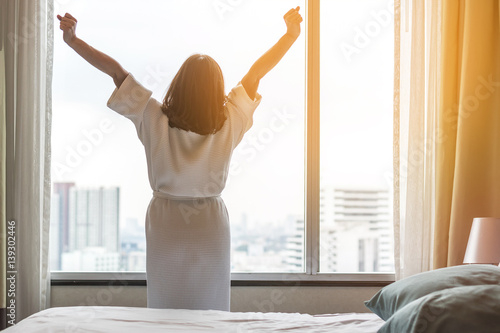 Easy lifestyle Asian woman waking up in the morning taking some rest relaxing in плакат