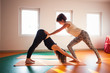 yoga instructor assisting student in exercis