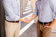 © Serhiy Hipskyy - Two businessman shaking hads to each other with street city blur background