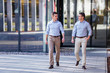 © Serhiy Hipskyy - Two businessman walking and talking about business with street city blur background