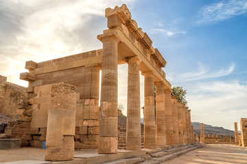 Wall Mural - Colonnade with portico main temple of Lindos Rhodes on the background of sunset clouds and the sun