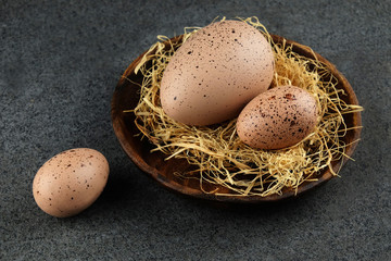 Easter eggs on wooden plate and dark table.