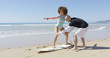 © Dash - The instructor explains the position to the woman standing on a surfboard in Tarifa beach, Cadiz, Spain.