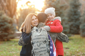 Canvas Print - USA soldier hugging his family outdoors