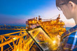 Double exposure of businesswoman in hipster shirt and wearing glasses working with tablet and oil and gas refinery industry plant in the night as Energy and Technology concept.