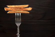 French Fries And Vintage Fork On A Dark Wooden Background.